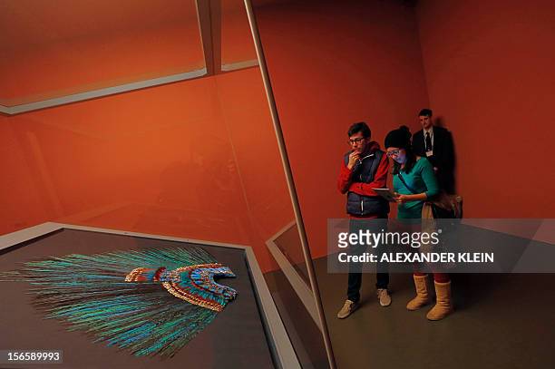 Mexican tourists look at the Penacho feather headdress allegedly worn by Aztec emperor Moctezuma II displayed at the Museum fur Volkerkunde in Vienna...