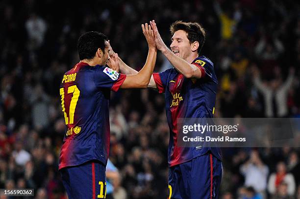 Lionel Messi of FC Barcelona celebrates with his teammate Pedro Rodriguez after scoring the opening goal during the La Liga match between FC...