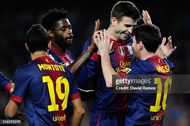 Lionel Messi of FC Barcelona celebrates with his teammates Gerard Pique and Alex Song after scoring the opening goal during the La Liga match between...