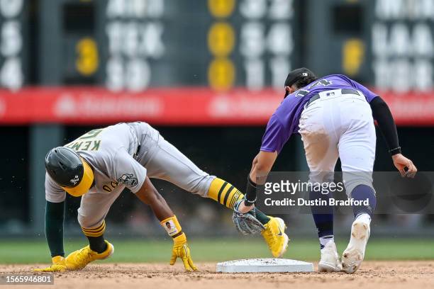Tony Kemp of the Oakland Athletics is tagged out by Ezequiel Tovar of the Colorado Rockies after sliding past second base on a steal attempt in the...