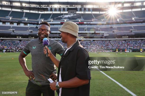 Former Newcastle United player Shola Ameobi is interviewed by entertainer Christian Crosby prior to a Premier League Summer Series match between...