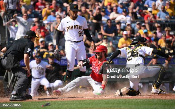 Bryce Harper of the Philadelphia Phillies is tagged out at home plate by Endy Rodriguez of the Pittsburgh Pirates as part of a double play in the...