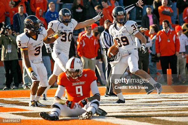 Luke Wollet, Leon Green, and Luke Batton, all of the Kent State Golden Flashes, celebrates after Wollet intercepted a pass intended for Shaun Joplin...