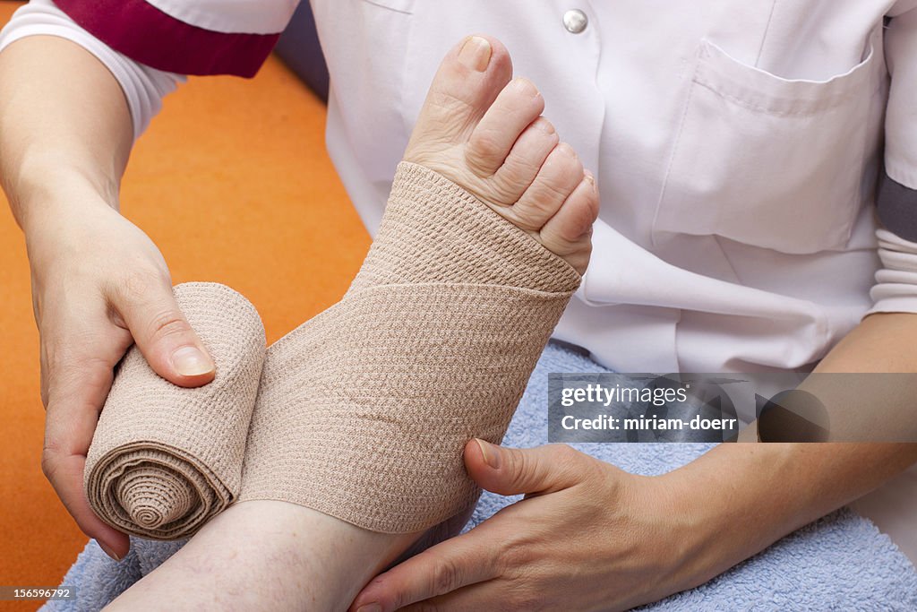 Doctor bandaged foot of a patient