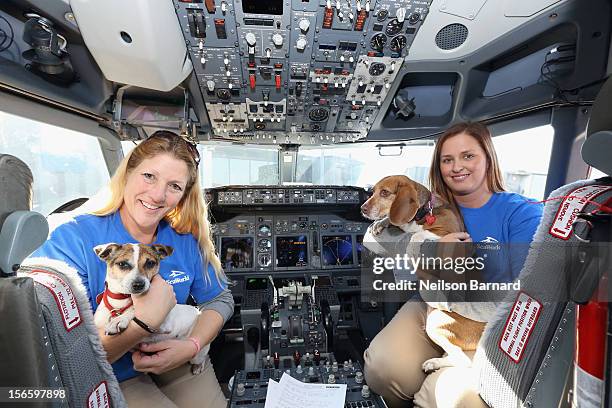 SeaWorld Rescue team members Anita Yeattes and Jessica Decoursey pose with two of the sixty orphaned dogs and cats who are being flown across the...