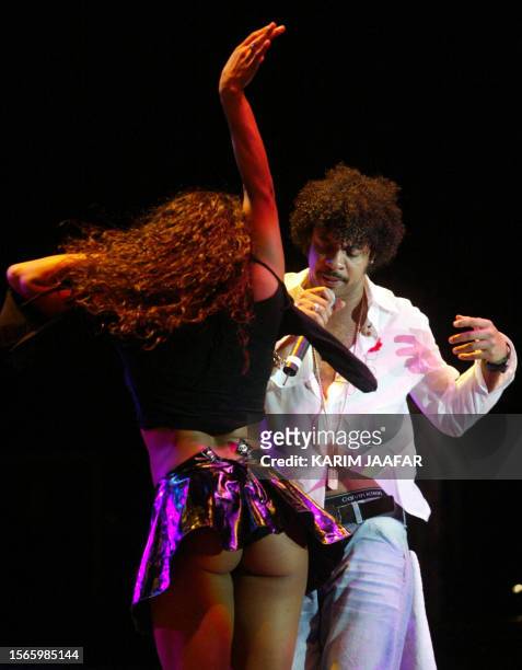 Singer Shaggy and a dancer perform at the Ritz-Carlton Hotel in Doha 09 December 2002 as part of the Qatar Sports Exhibition currently held in the...