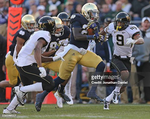 Cierre Wood of the Notre Dame Fighting Irish is chased by Kevin Johnson and Chibuikem Okoro of the Wake Forest Demon Deacons at Notre Dame Stadium on...