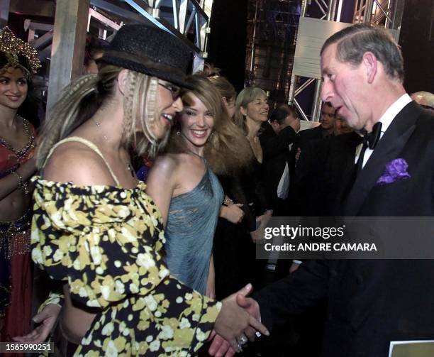 Britain's Prince Charles meets US pop star Anastacia while Australian singer Kylie Minogue watches backstage at the Apollo Theatre in London late 02...