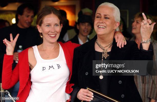 Singer Grace Slick jokingly gives the finger as she poses with her daughter China Kantner after being inducted in Hollywood's Rockwalk, in Los...