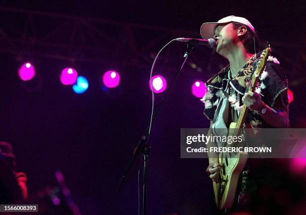 China's premier rock star Cui Jian plays to the crowd at the closing performance of the Snow Mountain Festival in Lijiang, 18 August 2002. This...