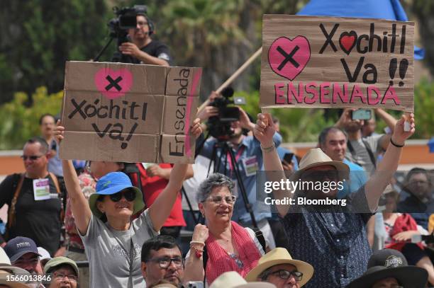 Supporters hold signs as Senator Xochitl Galvez, an opposition presidential candidate, not pictured, speaks during a campaign rally in Tijuana,...