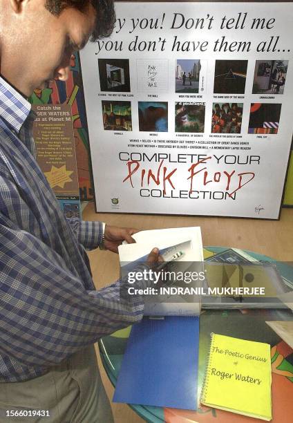 Satish a Delhi citizen, goes through a fan mail book to write his message to Roger Waters in a music store in Bangalore, 12 April 2002. Waters, part...