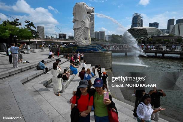 Tourists visit the Merlion Statue at Marina Bay in Singapore on July 31, 2023.