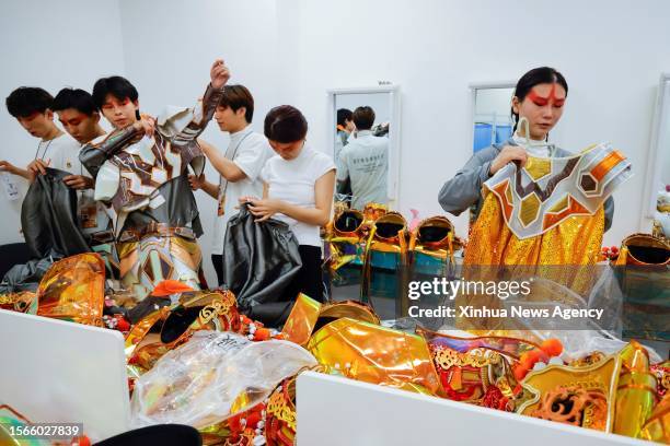 Ren Xin R and her fellow performers prepare their "bian lian" costumes prior to an opening ceremony rehearsal in Chengdu of southwest China's Sichuan...