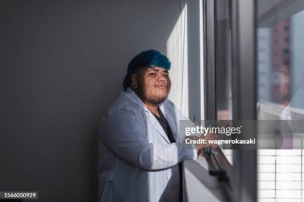 portrait of a transgender male healthcare professional - chin piercing stock pictures, royalty-free photos & images