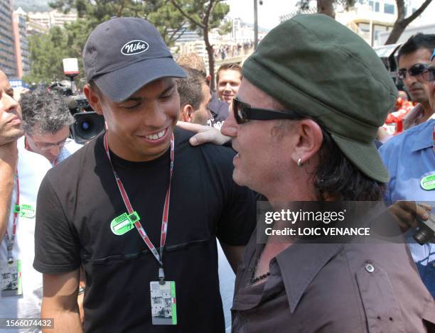 Irish popstar Bono chats with Brazilian international soccer player Ronaldo on the grid of the Monaco racetrack, 01 June 2003 before the start of the...