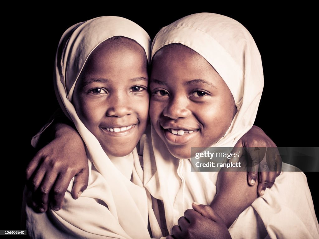 Dos niñas africanas musulmana (aislado en negro)