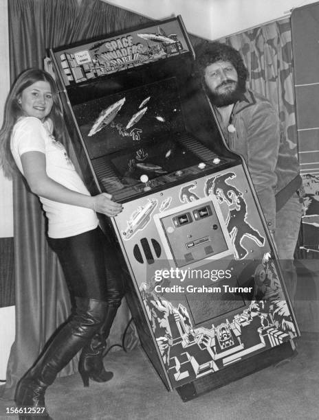 Radio 1 presenter Dave Lee Travis helping Mandy Strong to carry a Space Invaders arcade machine at St George's Hotel, Langham Place, London, 30th...