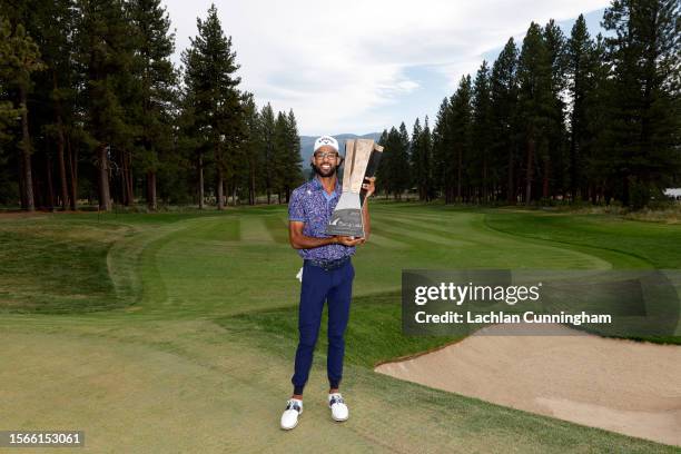 Akshay Bhatia of the United States poses with the trophy after putting in to win on the 18th green during a playoff during the final round of the...