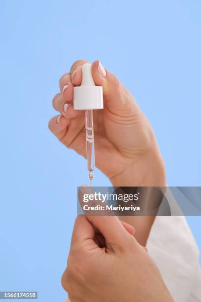 the girl applied a drop of oil to strengthen nails on her finger. - cuticula stockfoto's en -beelden