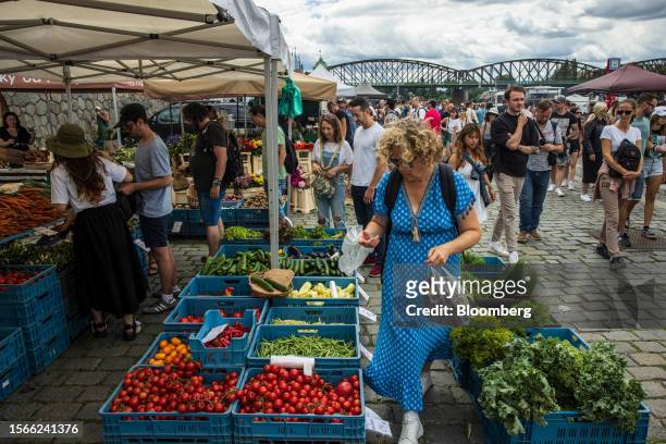 Shoppers browse crates of fresh produce on a stall at the Naplavka Farmers' Market on the banks of the River Vltava in Prague, Czech Republic, on...