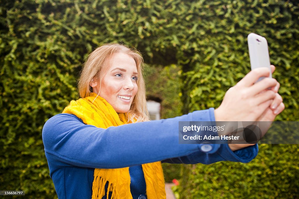 A young girl using a cell phone in a garden room.