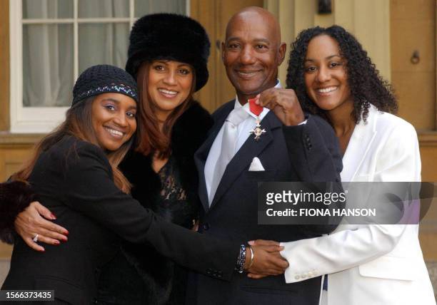 Hot Chocolate singer Errol Brown with his wife Ginette and daughters Leonie and Colette after receiving an MBE, for services to pop music, from Queen...