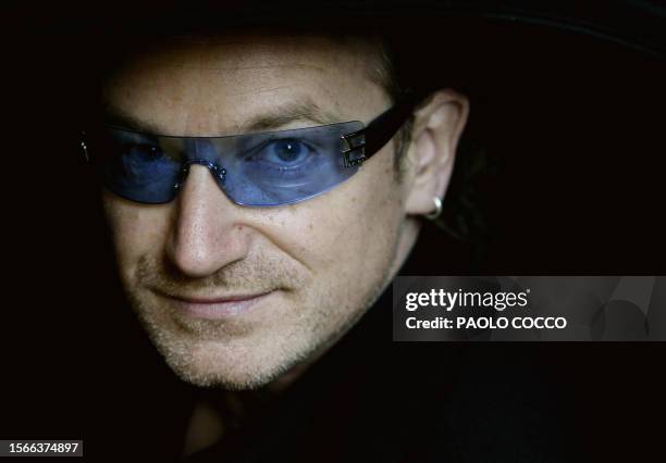 Irish singer Bono, lead singer of the rock group U2, peers out from a car's window after attending the wedding of famous tenor Luciano Pavarotti and...
