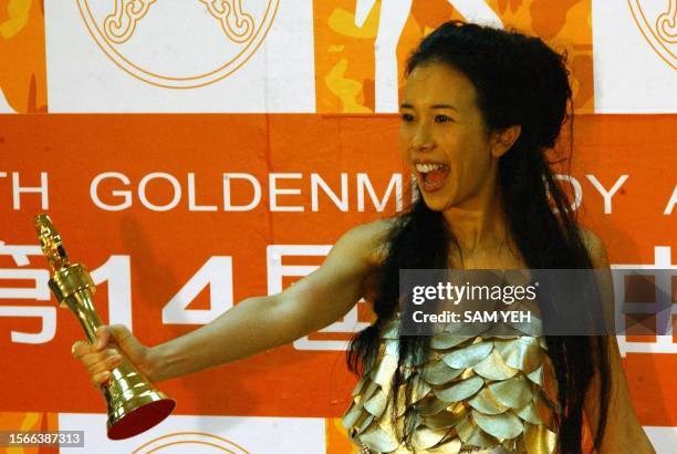 Hong Kong pop singer Karen Mok displays a trophy after she won the Best Singer during the 14th Golden Melody Awards in Taipei 02 August, 2003. More...