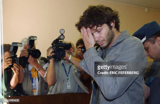 French pop star Bertrand Cantat is escorted by policemen while entering the court room 31 July 2003 in Vilnius. French actress Marie Trintignant...
