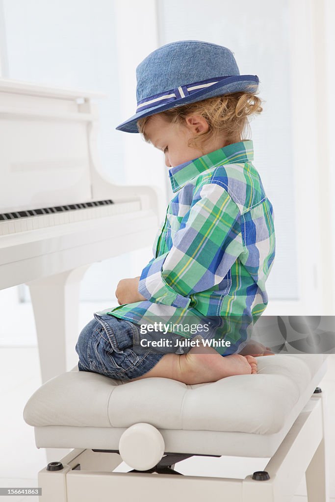 Young boy sitting at a piano