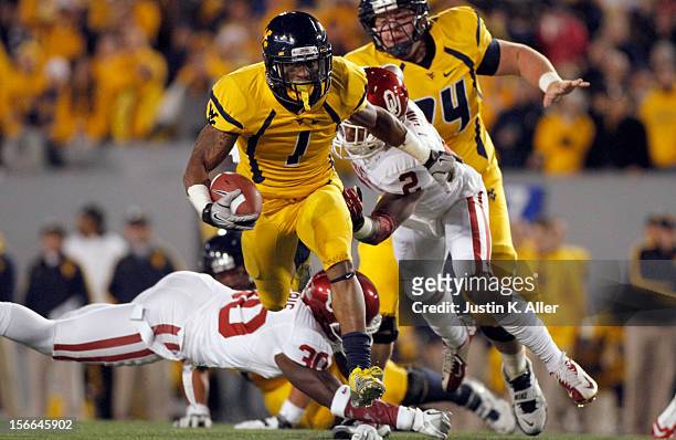 Tavon Austin of the West Virginia Mountaineers carries the ball against Julian Wilson of the Oklahoma Sooners during the game on November 17, 2012 at...