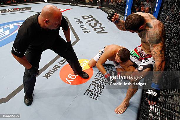 Alessio Sakara punches Patrick Cote in the back of the head as referee Dan Miragliotta looks on during their middleweight bout during UFC 154 on...