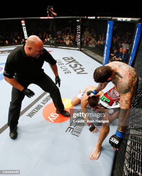 Alessio Sakara punches Patrick Cote in the back of the head as referee Dan Miragliotta looks on during their middleweight bout during UFC 154 on...