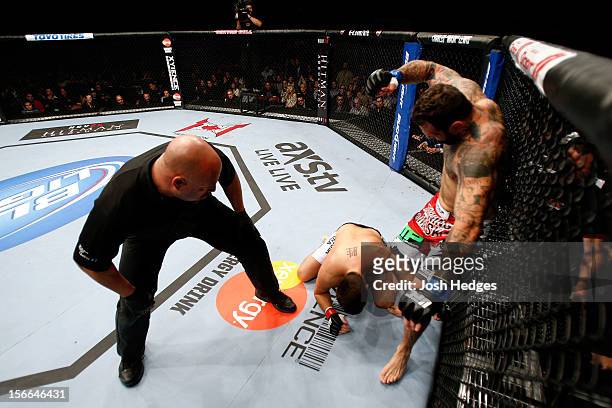 Alessio Sakara punches Patrick Cote in the back of the head as referee Dan Miragliotta looks on during their middleweight bout during UFC 154 on...