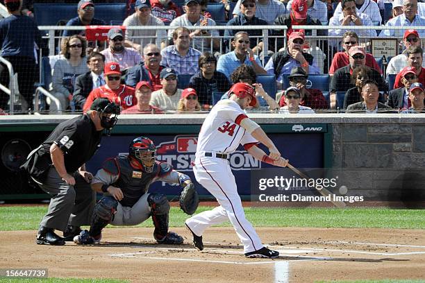 Outfielder Bryce Harper of the Washington Nationals flies out to rightfield during the bottom of the first inning of Game Three of the National...