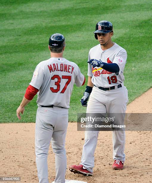 Outfielder Jon Jay of the St. Louis Cardinals receives congratulations from firstbase coach Chris Maloney#37 after Jay had singled to centerfield...