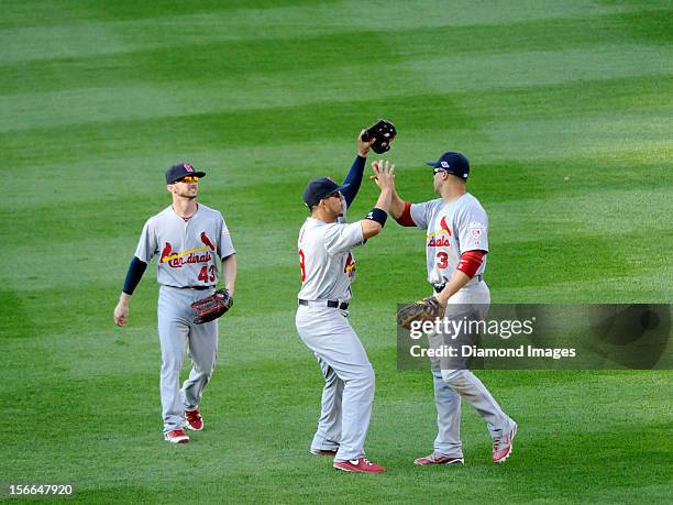 Outfielders Jon Jay and Carlos Beltran of the St. Louis Cardinals slap hands to celebrate the end of Game Three of the National League Division...