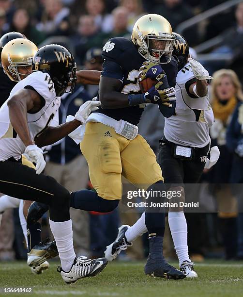 Cierre Wood of the Notre Dame Fighting Irish is chased by Kevin Johnson and Chibuikem Okoro of the Wake Forest Demon Deacons at Notre Dame Stadium on...