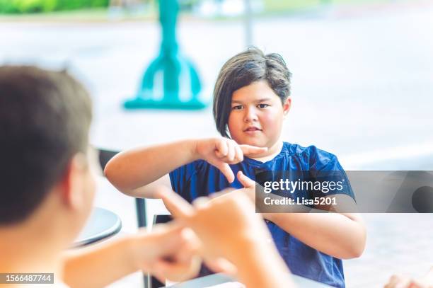 chinese american girl practices sign language - deafness stock pictures, royalty-free photos & images