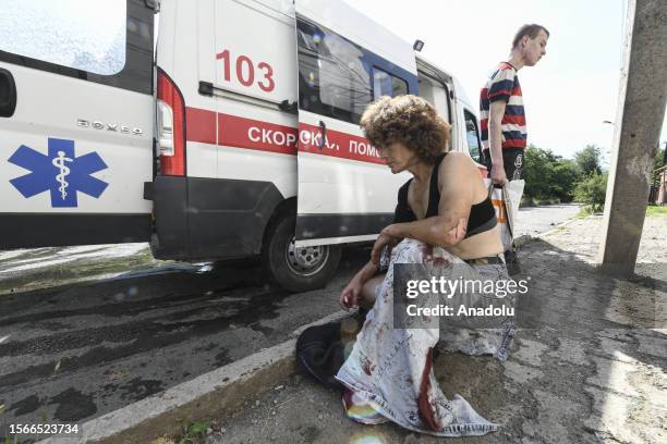 An injured women receives medical help at the scene after a shelling in the Russian controlled territory of Donetsk, Ukraine on July 31, 2023. At...