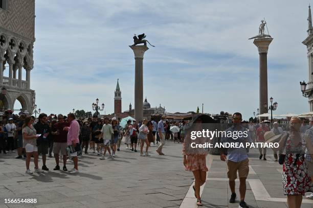 View taken on July 31, 2023 shows tourists walk across St. Mark's square in Venice. Unesco is recommending that Venice be placed on the list of World...