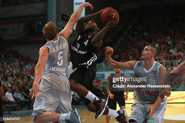 Tyrese Rice of Muenchen shoots against John Goldsberry of Bamberg and his team mate Maik Zirbes during the Beko Basketball match between Brose...