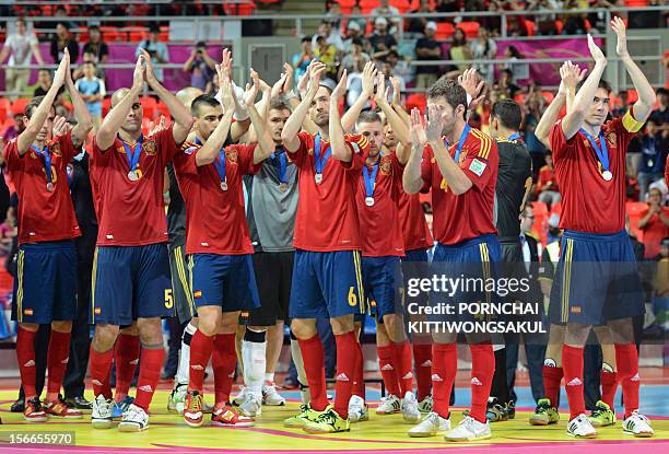 Spainish football players gesture to their fans after losing the final to Brazil during the trophy ceremony of the FIFA Futsal World Cup 2012 in...