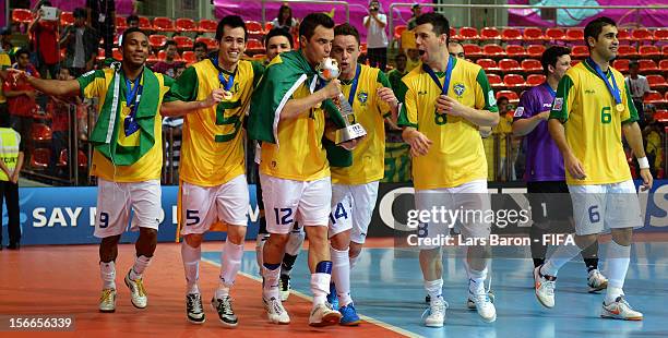 Falcao of Brazil kisses the trophy and celebrates with team mates after winning the FIFA Futsal World Cup Final at Indoor Stadium Huamark on November...