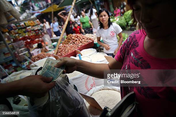 Woman pays as she shops for rice in at a market in Yangon, Myanmar, on Sunday, Nov. 18, 2012. President Barack Obama will become the first sitting...