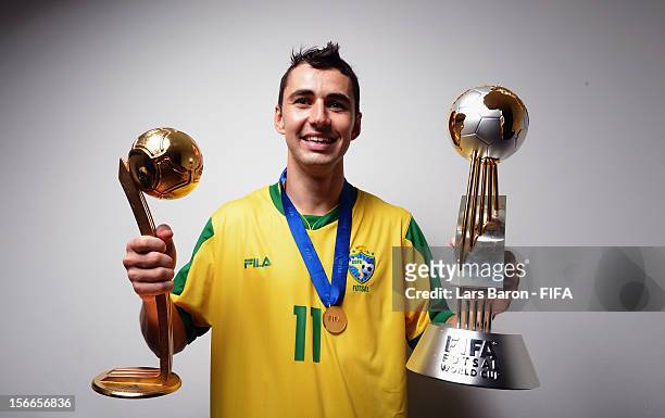 Neto of Brazil poses with the trophies in the locker room after winning the FIFA Futsal World Cup Final at Indoor Stadium Huamark on November 18,...