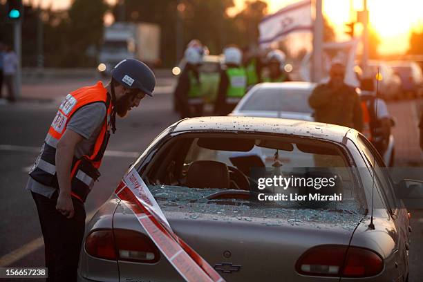 An Israeli emergency personnel inspects the damage to a car that was hit by a rocket fired by Palestinian militants from the Gaza Strip on November...