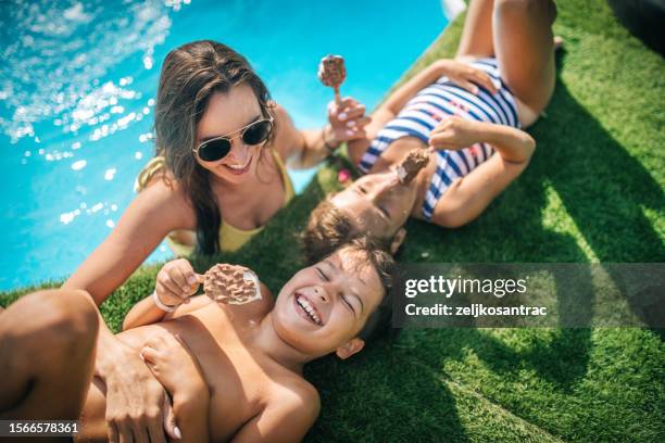 mehrgenerationenfamilie, die am rande sitzt - boy and girl eating ice cream stock-fotos und bilder