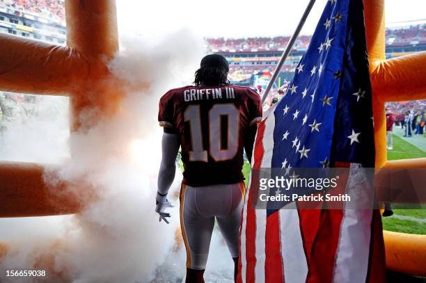 Quarterback Robert Griffin III of the Washington Redskins holds an American flag for Military Appreciation before being introduced against the...